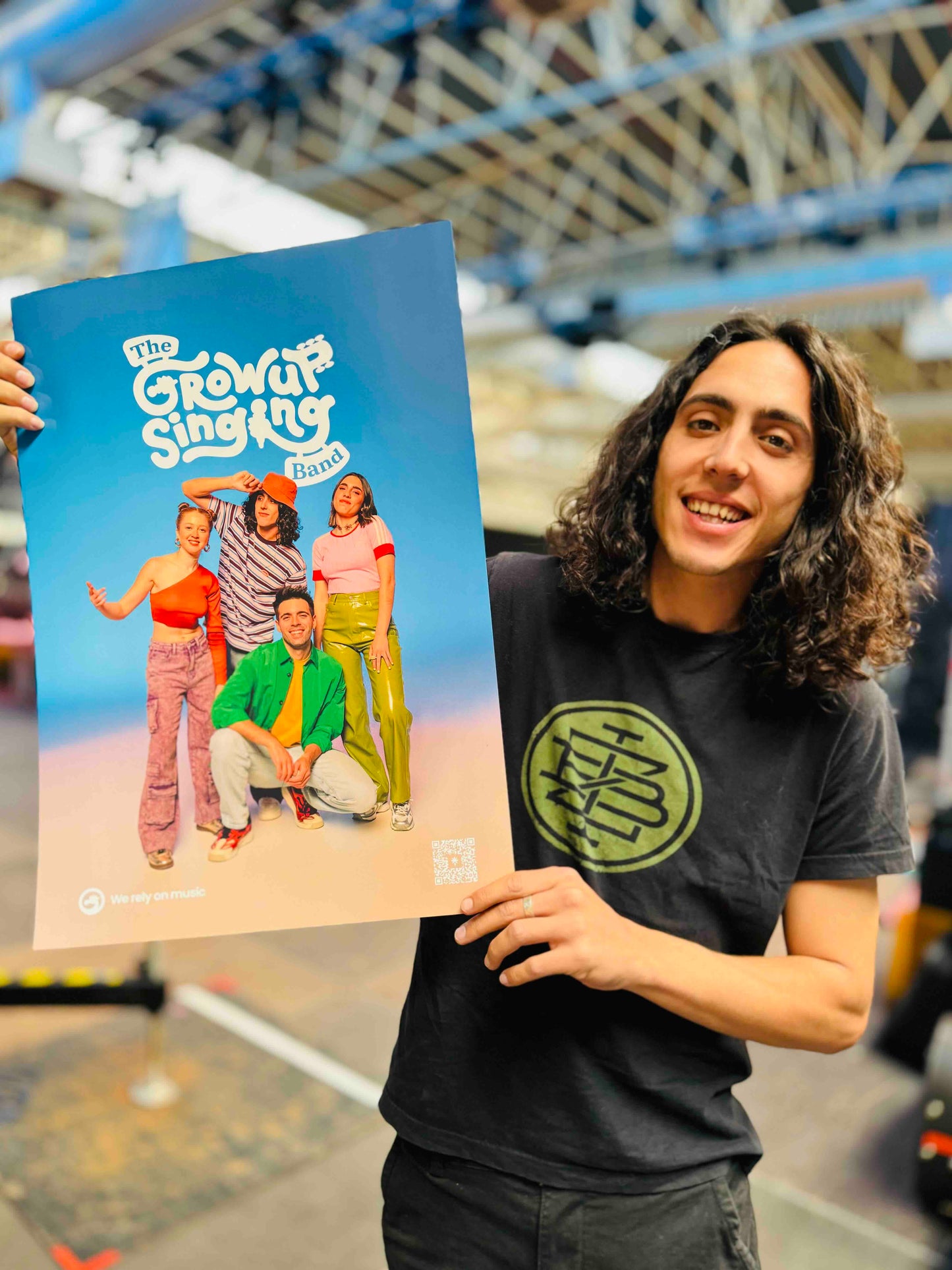 Adri mostrando el poster de THE GROW UP SINGING BAND
